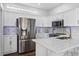 Bright kitchen featuring white cabinets, stainless steel appliances, stylish backsplash, and quartz countertops at 7747 33Rd E St, Sarasota, FL 34243