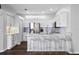 Well-lit kitchen with white cabinets, stainless steel appliances, tile backsplash, and modern barstools at the island at 7747 33Rd E St, Sarasota, FL 34243