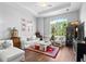 Bright and airy living room featuring hardwood floors, a large window, and stylish furniture at 7747 33Rd E St, Sarasota, FL 34243