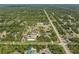 Expansive property with a pond and various structures visible from an aerial view, surrounded by dense trees at 8146 Tropicaire Blvd, North Port, FL 34291