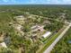 Lush, aerial view of a vast property featuring a home and agricultural buildings amidst dense trees at 8146 Tropicaire Blvd, North Port, FL 34291