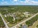 Aerial view of a large property with a home, pond, and various farm structures bordered by a road at 8146 Tropicaire Blvd, North Port, FL 34291