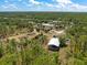 A lush, aerial view highlights a rural property with mature trees and structures, conveying a peaceful, secluded setting at 8146 Tropicaire Blvd, North Port, FL 34291