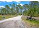 Long dirt driveway with a sign on a wooded lot at 8146 Tropicaire Blvd, North Port, FL 34291