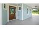 Attractive home featuring a wood front door and a spacious covered porch with ceiling fan at 8146 Tropicaire Blvd, North Port, FL 34291