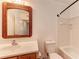 This bright bathroom features a wooden-framed mirror, a sink, and a bathtub with a shower at 1030 Villagio Cir # 103, Sarasota, FL 34237