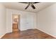 An uncluttered bedroom with wood-look floors and a view into the en-suite bathroom at 1030 Villagio Cir # 103, Sarasota, FL 34237