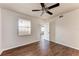 Simple, neutral bedroom features wood-look floors, a ceiling fan, and natural light from a window at 1030 Villagio Cir # 103, Sarasota, FL 34237