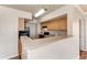 Features an open kitchen with wood cabinetry, black appliances, and a breakfast bar overlooking an adjacent room at 1030 Villagio Cir # 103, Sarasota, FL 34237