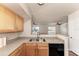 A kitchen featuring updated appliances and a breakfast bar looking out to an open living area with windows at 1030 Villagio Cir # 103, Sarasota, FL 34237