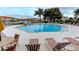 Community pool with lounge chairs, palm trees, and a fountain feature, perfect for relaxation and recreation at 1030 Villagio Cir # 103, Sarasota, FL 34237