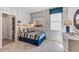 Comfortable bedroom featuring an accent wall, overhead lighting and a window with a blue shade at 10721 Tippecanoe Pl, Parrish, FL 34219