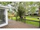 Wooden deck and railing overlooking a green backyard featuring mature trees and landscaping at 12107 45Th W Ave, Cortez, FL 34215