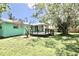 Exterior of a light blue home with a wooden deck, a green lawn, and shaded trees at 12107 45Th W Ave, Cortez, FL 34215