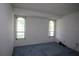 Empty bedroom with large windows, bright walls, and blue carpet, ready for customization at 12107 45Th W Ave, Cortez, FL 34215