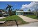 Charming home features a covered porch, attached garage, and well-manicured lawn at 12107 45Th W Ave, Cortez, FL 34215