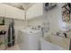 Practical laundry room with storage cabinets, sink and tile floors at 1245 Millbrook Cir, Bradenton, FL 34212