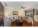 Cozy living room with hardwood floors, ceiling fan, and neutral-toned sofas overlooking the outside patio at 1245 Millbrook Cir, Bradenton, FL 34212