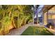 Serene backyard with artificial turf, stone ground cover, and tropical palm trees at 1530 Pine Bay Dr, Sarasota, FL 34231