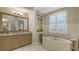 A luxurious bathroom featuring a soaking tub, granite counters and natural lighting at 1530 Pine Bay Dr, Sarasota, FL 34231