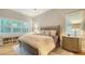 Well-lit bedroom featuring a bed with accent pillows and a side table with a lamp and built-in bookcase at 1530 Pine Bay Dr, Sarasota, FL 34231