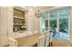 An open dining room featuring a large table with seating for eight, a wine bar, and sliding doors to the outside at 1530 Pine Bay Dr, Sarasota, FL 34231