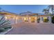 Exterior view of a luxurious home with a brick paved drive, a three car garage and beautiful landscaping at 1530 Pine Bay Dr, Sarasota, FL 34231