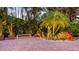 Professionally landscaped grounds with tropical plants, stone, and an outdoor bench at 1530 Pine Bay Dr, Sarasota, FL 34231