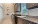 Laundry room features cabinetry, granite countertops, a utility sink, and a window at 1530 Pine Bay Dr, Sarasota, FL 34231