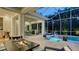 Screened-in patio featuring a pool, spa, and outdoor kitchen and dining area at 1530 Pine Bay Dr, Sarasota, FL 34231