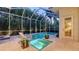 Beautiful backyard pool area featuring a tanning ledge, lush landscaping, and screened enclosure at 1530 Pine Bay Dr, Sarasota, FL 34231
