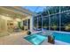 Inviting screened-in pool area with a tanning ledge, lush landscaping, and comfortable lounge chairs at 1530 Pine Bay Dr, Sarasota, FL 34231