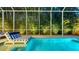 Screened-in pool area with lounge chairs and privacy landscaping at 1530 Pine Bay Dr, Sarasota, FL 34231