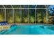Heated pool and spa surrounded by a screened enclosure and tropical plants at 1530 Pine Bay Dr, Sarasota, FL 34231