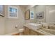 Stylish powder room with a modern vessel sink, elegant countertop, and decorative artwork on the wall at 1530 Pine Bay Dr, Sarasota, FL 34231