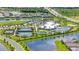 Aerial view showcasing community amenities including a clubhouse, pool, tennis courts, and lush landscaping at 15336 Serene Shores Loop, Bradenton, FL 34211