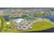 Expansive aerial view of a community featuring a lake, clubhouse with pool, tennis courts, and surrounding homes at 15336 Serene Shores Loop, Bradenton, FL 34211