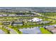 Aerial view showcasing community amenities including a clubhouse, pool, tennis courts, and lush landscaping at 15336 Serene Shores Loop, Bradenton, FL 34211