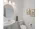 Bright bathroom featuring a pedestal sink, round mirror, and floral wall art at 15336 Serene Shores Loop, Bradenton, FL 34211