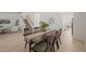 Stylish dining room adjacent to a staircase, featuring modern furniture, neutral paint, and tile floors at 15336 Serene Shores Loop, Bradenton, FL 34211