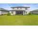 View of a two-story home from the backyard featuring green grass, landscaping, and a screened in patio at 15336 Serene Shores Loop, Bradenton, FL 34211