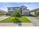 Charming two-story home with a three-car garage, well-manicured lawn, and lush landscaping at 15336 Serene Shores Loop, Bradenton, FL 34211