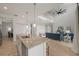 Open-concept kitchen with an island and seating, flowing into a living room with high ceilings and stylish decor at 15336 Serene Shores Loop, Bradenton, FL 34211