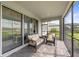 Screened patio featuring brick flooring, neutral colored furniture, and sliding glass doors to the interior of the home at 15336 Serene Shores Loop, Bradenton, FL 34211