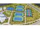 Aerial image of a community with multiple tennis courts, basketball court, putting green, and lush landscaping at 15336 Serene Shores Loop, Bradenton, FL 34211