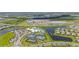 Wide aerial view showcasing community amenities: tennis courts, a pool, and a large parking area by a lake at 15336 Serene Shores Loop, Bradenton, FL 34211