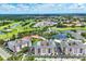 A picturesque aerial view of the condo community, featuring a pond with a walking bridge and lush landscaping at 1613 Gondola Park Dr # 1613, Venice, FL 34292