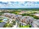 The aerial view shows a sprawling condo community with lake, lush landscaping, and neatly arranged residential buildings at 1613 Gondola Park Dr # 1613, Venice, FL 34292