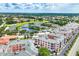 A beautiful aerial view showcases the condo community, featuring a lake, a swimming pool, and vibrant green landscaping at 1613 Gondola Park Dr # 1613, Venice, FL 34292