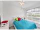 Bright bedroom with a ceiling fan, white furniture, and colorful pillows on the bed at 1613 Gondola Park Dr # 1613, Venice, FL 34292